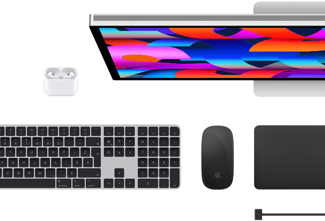 Vue en plongée d’accessoires pour Mac : un Studio Display, des AirPods, un Magic Keyboard, une Magic Mouse et un Magic Trackpad